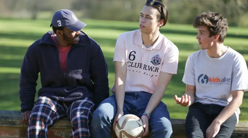 Group of young men sitting outside