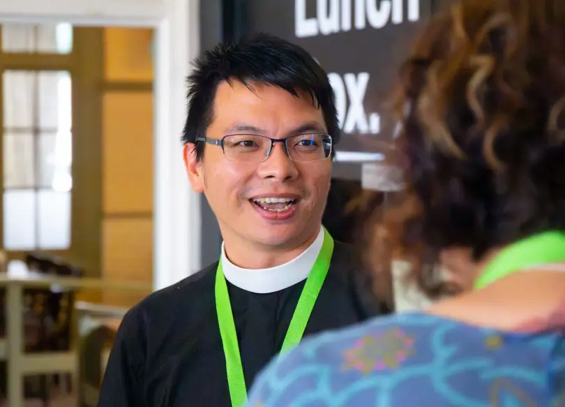 A priest talking to a group member