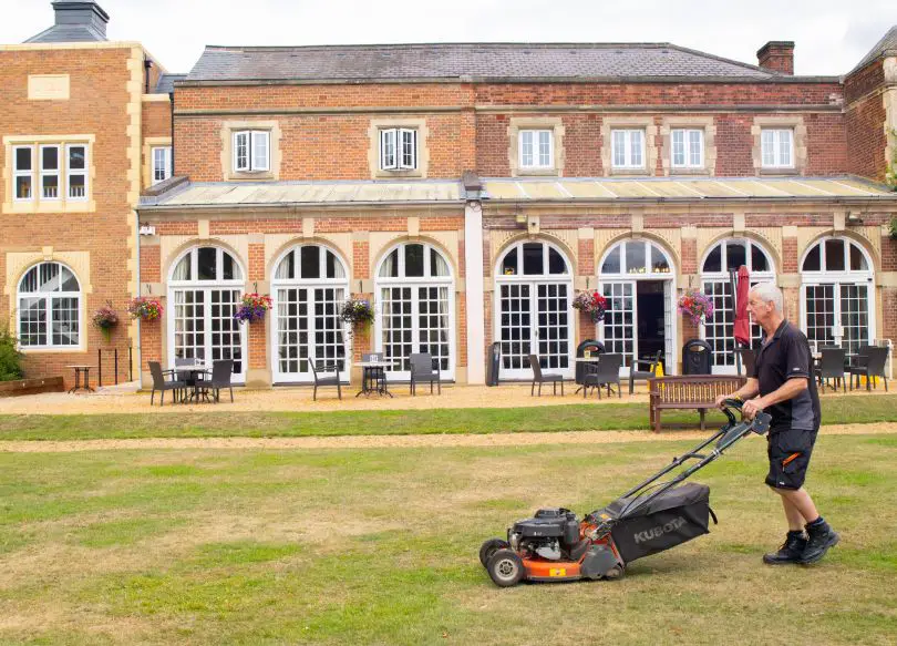 Gardener cutting the lawn at High Leigh