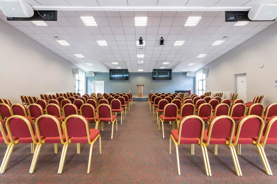 A view of Yew Tree Hall set in theatre style looking at the front of the room with the large tv screens.