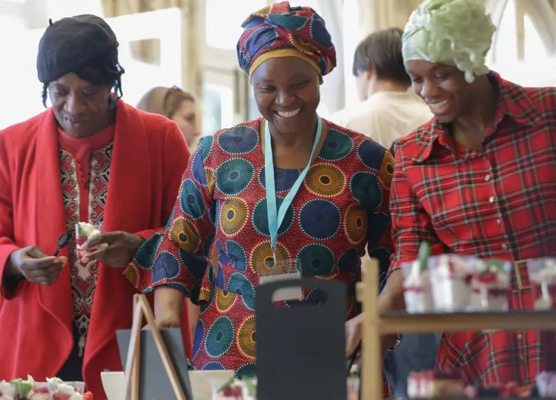 Three ladies choosing food from a buffet