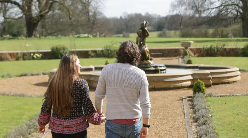 A couple walking towards a fountain