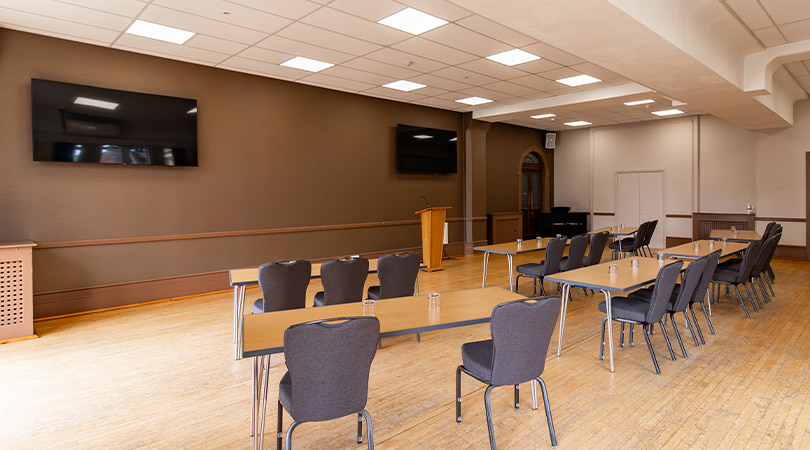 Large conference hall with stage and rows of chairs