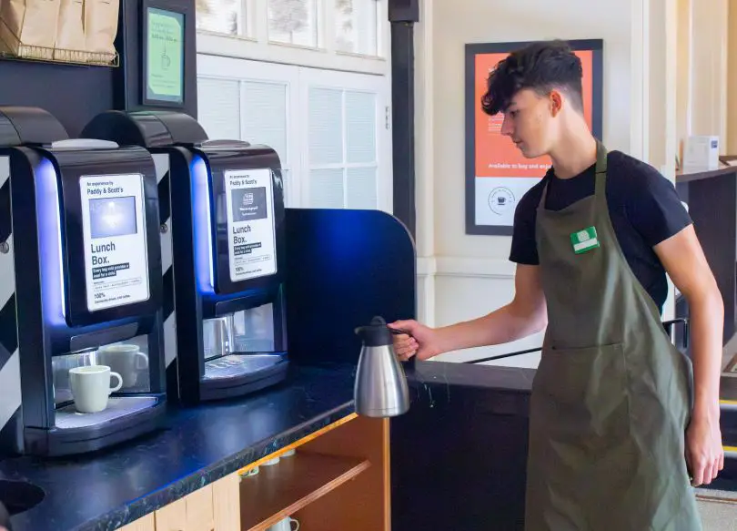 Young lad using a drink dispenser