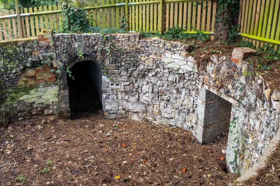 The sunken pump house with no roof showing a circular room with 2 doorways leading to dead ends.