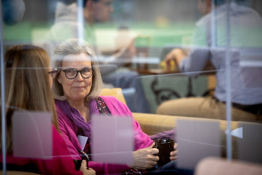 A woman in the bar area at The Hayes talking to another woman over a coffee.