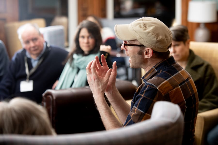 A man with a beige cap on leading a seminar session