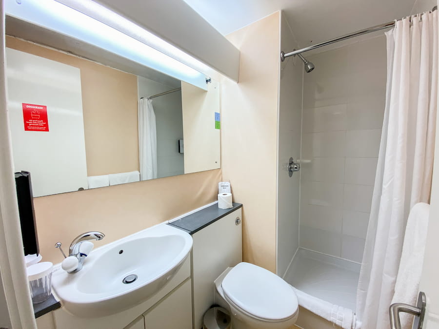 A cherry bathroom before the renovations with yellow/cream walls.