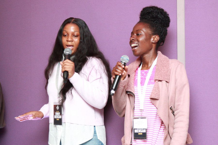 2 youth members on stage singing together.