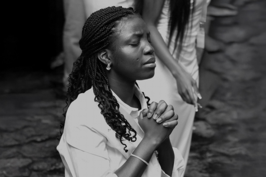 A youth member on her knees praying to God.