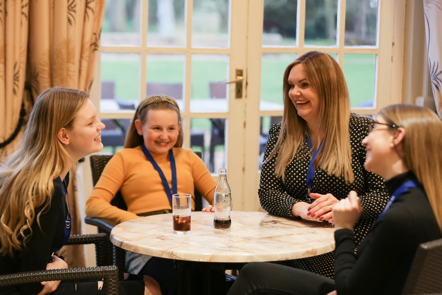 A mum and 3 kids laughing in the coffee lounge at one of our venues.