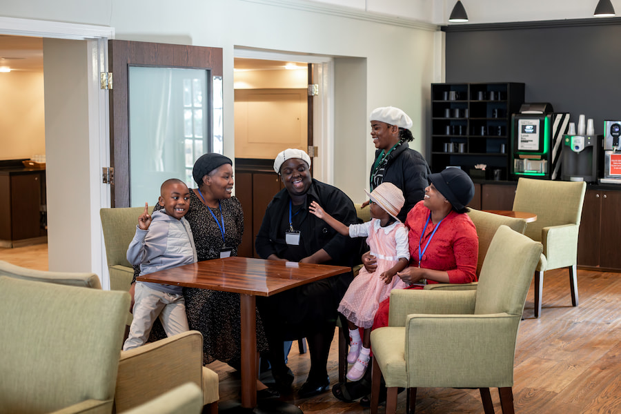A family sitting in the coffee lounge talking and laughing at one of our venues.
