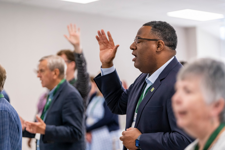 A man worshipping with his eyes closed at one of our venues with many Christians around him.