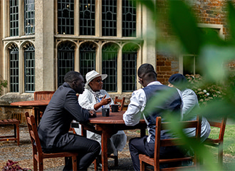 A Church group sitting outside of Highgate House on a warm Spring day