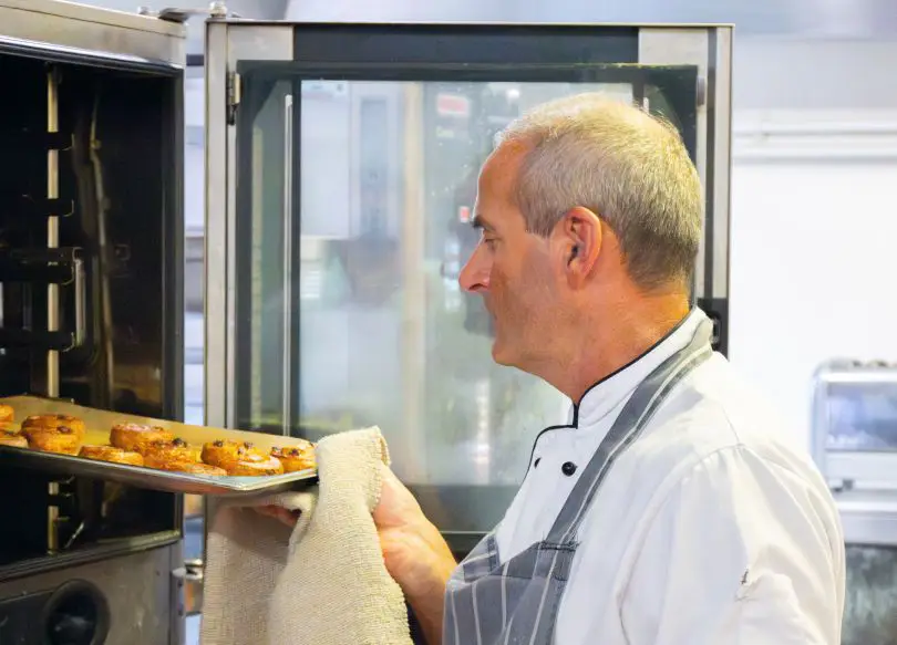 Chef taking tray from oven